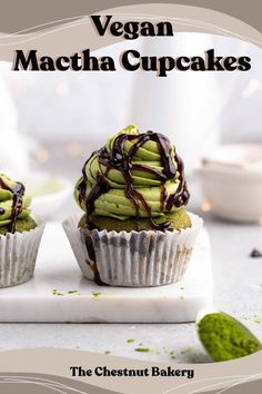 two cupcakes with chocolate drizzled on top and green frosting