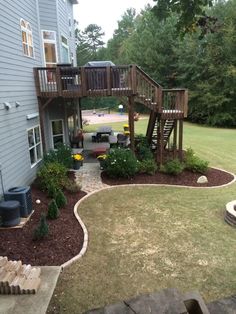 a house with landscaping in front of it and stairs leading up to the second story