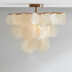 a chandelier hanging from the ceiling in a room with white walls and flooring