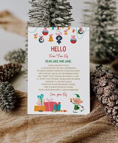 there is a card that says hello from santa and has presents on the front, with pine cones in the background