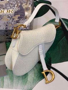 Description CHRSTN DR Saddle Bag White DYOR Oblique Embroidered Canvas Gold toned hardware For Women 25cm/10in CD Rep 1:1 Dimensions: 25.5 x 20 x 6.5 cm / 10 x 8 x 3 inches The iconic Saddle bag, crafted in white , is reimagined by Maria Grazia Chiuri. The legendary design is embellished with a DYOR Oblique perforations motif and features a Saddle flap with a magnetic ‘D’ stirrup clasp and an antique gold-finish metal ‘CD’ signature on either side of the strap. The bag has a wide embroidered str Designer White Bag With Embroidered Logo, Luxury White Saddle Shoulder Bag, Designer White Embroidered Bag, Luxury Leather Shoulder Bag With Embroidered Logo, Classic White Saddle Bag With Detachable Strap, Christian Dior Saddle Bag, Louis Vuitton Shirt, Dior Oblique, Dior Saddle