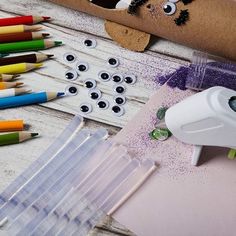 some crayons and markers are sitting on a table next to crafting supplies