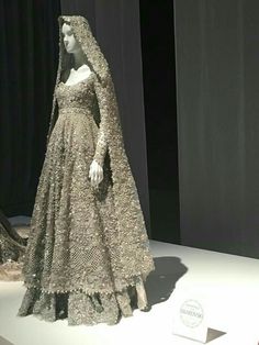 a mannequin dressed in a wedding dress and veil on display at a museum