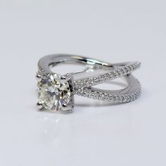 a diamond ring with two bands around it on a white surface, set in 18k white gold