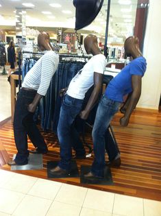 three mannequins are standing in front of a store window