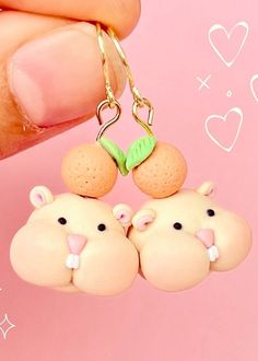 two small toy animals hanging from a pair of earrings