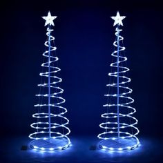 two lighted christmas trees with stars on them