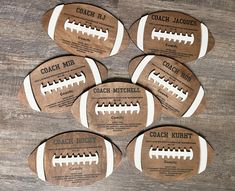 six football coasters with the names coach mar written on them, sitting on a wooden surface