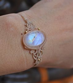 a woman's hand with a bracelet made out of lace and an oval glass cabochon