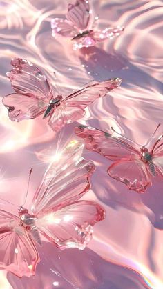 three pink butterflies floating in water with ripples on the surface and light reflecting off them