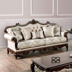 a living room with a couch, table and chair next to each other in front of a white wall