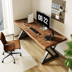 a computer desk with a clock on it next to a chair and potted plant