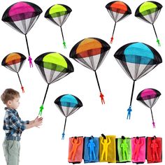 a young boy standing in front of a bunch of kites with different colors on them