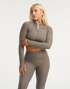 The Rise series awakes - taking ECHT's seamless fabric to a new level. This cropped long sleeve is made of a soft and flexible ribbed fabric and sits comfortably across the waist to accentuate your silhouette. Featuring full zip from collar to waist to keep you warm or cool, thumb holes and advanced heat pressed silicone ECHT logo. The Rise Zip up long sleeve paired with marching Rise Leggings is suitable for all day wear and low intensity workouts. - Seamless fabric with a ribbed structure - Sweat-wicking and breathable - Super soft peach-like sensation feel - Thumb holes to keep fingers warm - Cropped waist length - Zip from collar to waist 76% Nylon, 24% Spandex Phoebe is wearing a Small, and is 5'4" Snug Fit Long Sleeve Ribbed Tops, Snug Fit Ribbed Long Sleeve Tops, Ribbed Long Sleeve Sports Activewear, Long Sleeve Stretch Crop Top, Seamless Fitted Long Sleeve Activewear, Stretch Long Sleeve Crop Top With Thumbholes, Long Sleeve Stretch Crop Top With Thumbholes, Seamless Long Sleeve Gym Tops, Winter Cropped Stretch Activewear