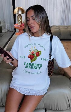 Farmers Market Strawberry Classic Tee. Please note this tee is true to size If you want an oversized tee like the one in the pictures you will need to go up a few sizes.  Model in the pictures is wearing an 2XL. Please refer to the size guide for your correct sizing. As these tees are custom made we are unable to offer returns due to wrong sizing. Please ensure you are measuring for sizing, if you are unsure I recommend comparing it to a tee you already own.  Made with 100% Cotton  FAQ - How long will it take to receive my order? Production time: * 2-3 business days Delivery times: * USA = standard shipping: 2-5 business days = economy shipping: 4-8 business days  * United Kingdom: 5-7 days  * Europe: 5-10 days * Australia: 5-10 days * Canada: 5-10 days * Rest of the world: 7-10 days Oversized Text Print T-shirt For Spring, Oversized Letter Print Tops For Spring, Oversized Spring Slogan Tops, Oversized Graphic Print T-shirt For Spring, Oversized Printed Graphic Tee, Oversized Screen Print T-shirt For Spring, Oversized Short Sleeve Slogan Shirt, Oversized Graphic Tee With Print, Retro Oversized Shirt With Letter Print