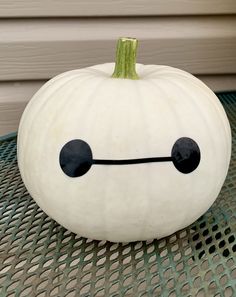 a white pumpkin sitting on top of a metal table