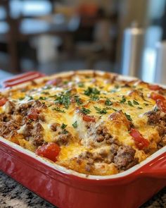 a casserole dish with meat, cheese and tomatoes