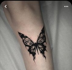 a black and white butterfly tattoo on the left leg, with an arrow in the middle