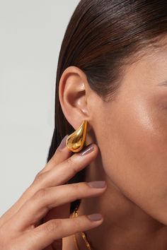 These Agnes Earrings boast a sleek teardrop silhouette; they are minimal and classy, perfect for any occasion! The simple design is perfect for accenting any outfit, whether it be casual or formal. ………………………………….D E T A I L S• Materials: Stainless steel, 18k gold plating.• Length: 30mm • This product is hypoallergenic, water and tarnish resistant Fancy Earrings Classy, Minimal Gold Earrings, Sleek Earrings, Earrings Photography, Gold Statement Jewelry, Chunky Gold Hoop Earrings, Classy Earrings, Tear Drop Earrings, Romantic Design