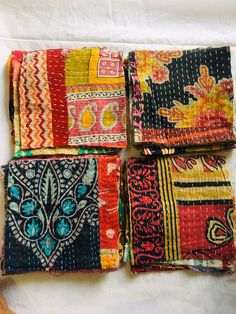 four pieces of colorful cloth laid on top of each other in different patterns and colors