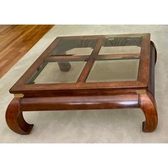 a coffee table with glass top and wooden legs