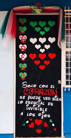 a sign on the side of a building that has hearts drawn on it and words written in spanish