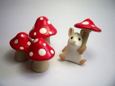 a small toy mouse standing next to some mushrooms