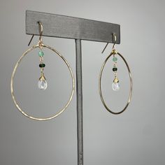 Details: This set includes a matching ruby and rainbow moonstone set. Hoops ~Hand hammered hoops.~Gold filled.~Ombre rubies or emeralds.~Rainbow moonstone focal stone.~Hoops measure approximately 1 1/2" in diameter.~Earrings measure approximately 2 1/4” from the top of the hook to the bottom of the bottom hoop. Necklace ~Gold filled.~Ombre rubies or emerald.~Rainbow moonstone focal stone.~9mm lobster clasp.~Measures 20".~1” extension that allows you to adjust the length of the necklace.~Little gem embellishment stone on the end of the extension chain. Everyday Spiritual Hammered Jewelry, Modern Gemstone Hoop Earrings For Gift, Modern Gemstone Hoop Earrings As Gift, Elegant Hoop Jewelry With Gemstone Accents, Sterling Silver Hoop Earrings For May Birthstone, May Birthstone Hoop Gemstone Jewelry, Modern Oval Moonstone Jewelry, Modern Handmade Small Hoop Jewelry, Gemstone Hoop Jewelry Gift