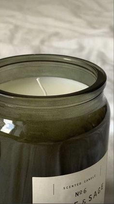 a close up of a candle on a table with a white sheet in the background