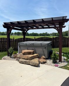 an outdoor hot tub in the middle of a yard with rocks and plants around it