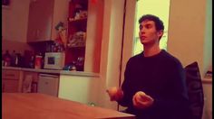 a man standing in front of a kitchen counter holding an apple and looking at the camera