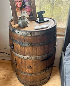 a wooden barrel with two pictures on it and a photo frame sitting on top of it