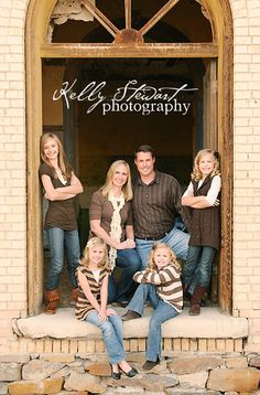 a family posing for a photo in front of a window with the words wild heart photography on it