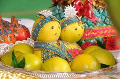 two oranges and three lemons in a bowl on a table with other decorations