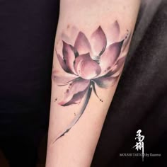 a woman's arm with a pink flower tattoo on it