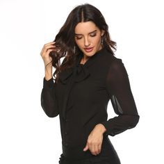 This bodysuit design showcases a decorative bow, full row of buttons running down it's length while the integrated underwear part ensures a comfortable and secure fit. Tailored for a flawless silhouette with secure bodysuit design. Made from Chiffon, a soft polyester blend for comfort and longevity. A chic yet versatile piece that transitions seamlessly from office to casual engagements. Please note: Theitem's label will display two sizes bigger than your chosen size. Elegant Solid Color Bodysuit For Fall, Fitted Bow Tie Blouse For Party, Fitted Party Blouse With Bow Tie, Elegant Formal Spring Bodysuit, Elegant Stretch Top With Bow, Fitted Party Tops With Bow Tie, Fitted Bow Tie Tops For Party, Fitted Tie Neck Blouse With Button Closure, Elegant Stretch Blouse With Buttons