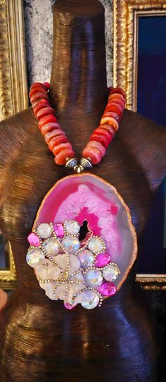 After a re-stringing repair, this piece is now ready for a new home! A 7" x 5" hot pink and Fuchsia Brazilian agate hosts a rough white quartz cluster, faux clear and pink crystals and rows of silver aurora borealis rhinestones! The pendant is suspended from an agate rondelle statement necklace which measures 21". The reddish-pink agates are polished on one side and rough on the other. Each agate is spaced with an ornate silver tone metal bead. Flanking the pendant are rhinestone rondelles and silver tone stamped tribal bi-cone beads. The back is finished with more tribal beads, rhinestone rondelles, frosted pink druzy agates and clear faceted crystals. Closes with a fancy silver tone hook and eye. This is a very dense and heavy piece so please know your tolerance before you buy. From the Pink Agate Gemstone Bead Necklace, Artisan Pink Gemstone Beads Jewelry, Artisan Pink Gemstone Jewelry, Coral Gemstone Jewelry For Weddings, Unique Pink Jewelry With Stones, Pink Ruby Necklace For Party, Pink Agate Pendant Necklace, Pink Agate Gemstone Jewelry, Unique Pink Gemstone Necklace