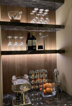 the shelves are filled with wine glasses and other items on top of them, including oranges