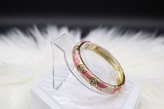 The Pink Enamel Bangle Hinged Bracelet is a charming and elegant accessory, showcasing a soft pink enamel finish that exudes a sense of grace and sophistication. Its hinged design provides ease of wear and removal, making it a versatile addition to your jewelry collection, perfect for adding a touch of femininity to your outfits. Pink Metal Bracelets For Wedding, Elegant Enamel Bangle Bracelets, Pink Bangle For Formal Occasions, Pink Metal Jewelry As Fashion Accessory, Pink Metal Jewelry Fashion Accessory, Pink Formal Bangle Jewelry, Adjustable Pink Enamel Jewelry, Pink Round Cuff Bracelet For Gifts, Pink Metal Bangle Bracelet