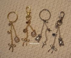 four different types of key chains with charms attached to them on a carpeted surface