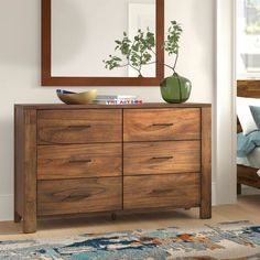 a wooden dresser sitting in front of a mirror