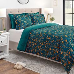 a bed with green and yellow comforters in a bedroom next to a white nightstand