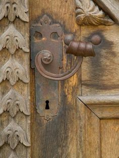 an ornate door handle on a wooden door