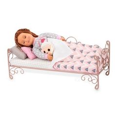 a doll laying on top of a bed with a teddy bear