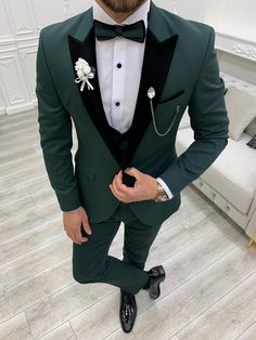 a man in a green tuxedo with a white flower on his lapel