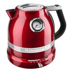 a red electric kettle sitting on top of a white table next to a black handle