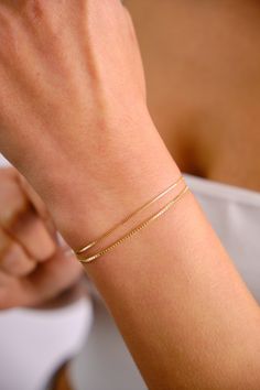 ABOUT PRODUCT A 14K gold box chain bracelet is a sophisticated and stylish accessory made of high quality gold. It features small, square links in a smooth and uniform chain design, making it dainty and delicate. This bracelet is perfect for everyday wear and can be dressed up or down for any occasion. It can be worn on its own as a minimalist statement piece or layered with other bracelets for a more sophisticated look. A 14K gold box chain bracelet is a timeless and elegant choice for women of Box Chain Bracelet, Chain Bracelets Gold Simple For Women, Gold Bracelet Simple, Layered Bracelet, Simple Chain, Bracelet Simple, Dainty Bracelet, Gold Bracelet For Women, Gold Bracelets