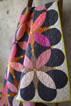 a colorful quilt is hanging up on a chair