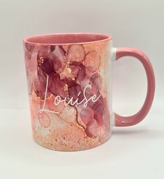 a pink and white coffee mug with the word louise painted on it