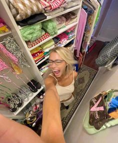 a woman standing in front of a closet filled with shoes